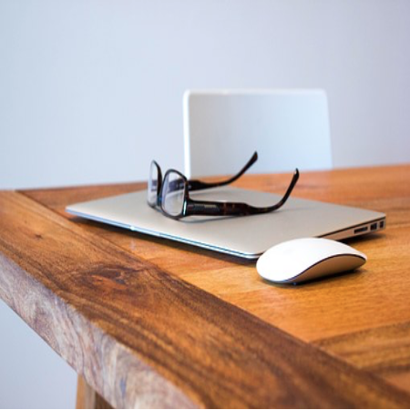 Laptop, glasses and mouse sitting on a desk